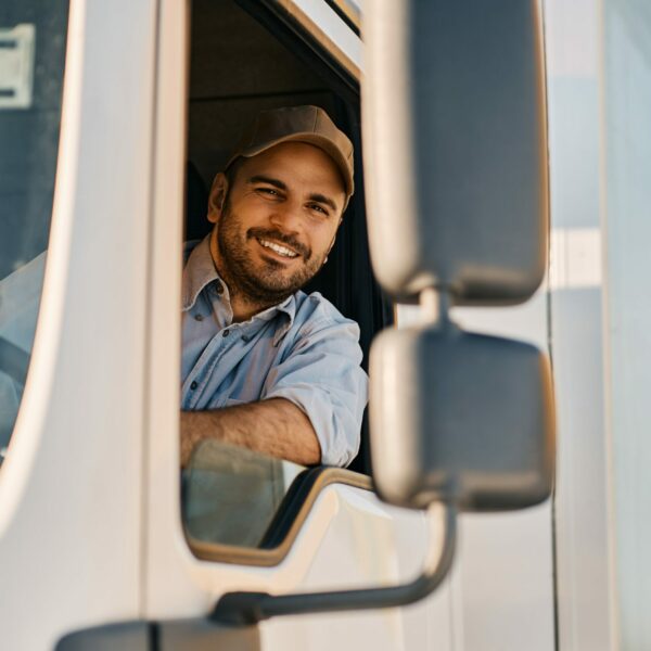 happy-truck-driver-looking-through-side-window-whi-2022-11-29-22-44-05-utc-min